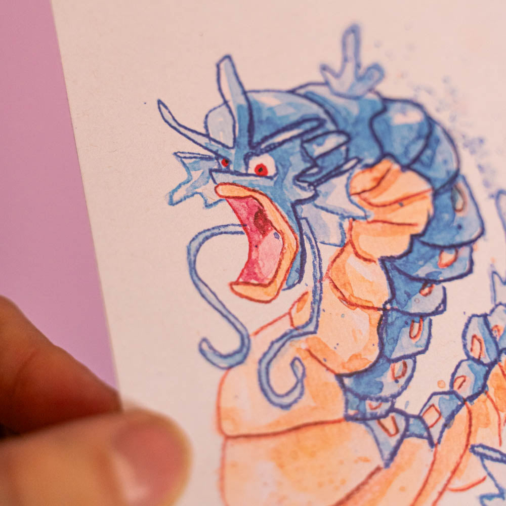 Carte postale Léviator (Edition Moche) -Carte postale imprimée d’une illustration réalisée à l'aquarelle et aux crayons de couleurs.Le dessin vient d'un challenge en live sur Twitch dans lequel j'ai dessiné les 151 Pokémon de la première génération de 1995 en 24h en live sur Twitch, MAIS : en moche ! Voir la vidéo : https://youtu.be/0MyLD5bqc1Q Papier 300g recyclé. Possibilité de la faire signer et dédicacer à la main en choisissant l'option de livraison "Dédicacée".-Brunograffer Carte postale Léviator (Edition Moche) -Carte postale imprimée d’une illustration réalisée à l'aquarelle et aux crayons de couleurs.Le dessin vient d'un challenge en live sur Twitch dans lequel j'ai dessiné les 151 Pokémon de la première génération de 1995 en 24h en live sur Twitch, MAIS : en moche ! Voir la vidéo : https://youtu.be/0MyLD5bqc1Q Papier 300g recyclé. Possibilité de la faire signer et dédicacer à la main en choisissant l'option de livraison
