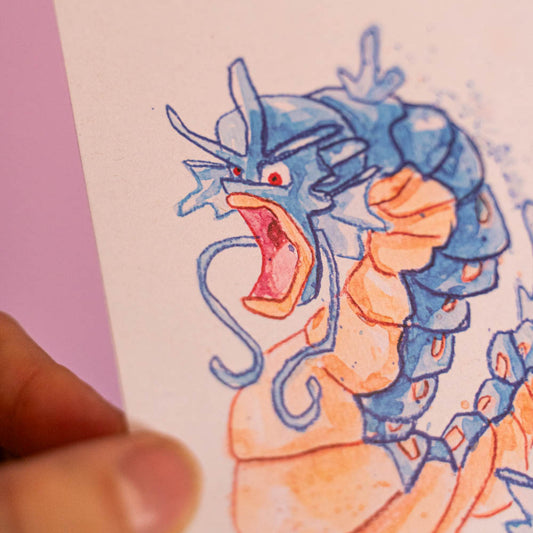 Carte postale Léviator (Edition Moche) -Carte postale imprimée d’une illustration réalisée à l'aquarelle et aux crayons de couleurs.Le dessin vient d'un challenge en live sur Twitch dans lequel j'ai dessiné les 151 Pokémon de la première génération de 1995 en 24h en live sur Twitch, MAIS : en moche ! Voir la vidéo : https://youtu.be/0MyLD5bqc1Q Papier 300g recyclé. Possibilité de la faire signer et dédicacer à la main en choisissant l'option de livraison "Dédicacée".-Brunograffer Boutique Art de Brunograffer - Carte postale imprimée d’une illustration réalisée à l'aquarelle et aux crayons de couleurs.Le dessin vient d'un challenge en live sur Twitch dans lequel j'ai dessiné les 151 Pokémon de la première génération de 1995 en 24h en live sur Twitch, MAIS : en moche !
 
 
Voir la vidéo : https://youtu.be/0MyLD5bqc1Q
 
Papier 300g recyclé.
Possibilité de la faire signer et dédicacer à la main en choisissant l'option de livraison "Dédicacée".