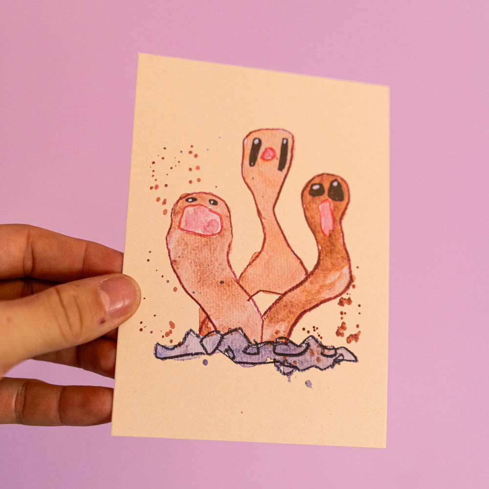 Carte postale Triopiqueur (Edition Moche) -Carte postale imprimée d’une illustration réalisée à l'aquarelle et aux crayons de couleurs.Le dessin vient d'un challenge en live sur Twitch dans lequel j'ai dessiné les 151 Pokémon de la première génération de 1995 en 24h en live sur Twitch, MAIS : en moche ! Voir la vidéo : https://youtu.be/0MyLD5bqc1Q Papier 300g recyclé. Possibilité de la faire signer et dédicacer à la main en choisissant l'option de livraison "Dédicacée".-Brunograffer Carte postale Triopiqueur (Edition Moche) -Carte postale imprimée d’une illustration réalisée à l'aquarelle et aux crayons de couleurs.Le dessin vient d'un challenge en live sur Twitch dans lequel j'ai dessiné les 151 Pokémon de la première génération de 1995 en 24h en live sur Twitch, MAIS : en moche ! Voir la vidéo : https://youtu.be/0MyLD5bqc1Q Papier 300g recyclé. Possibilité de la faire signer et dédicacer à la main en choisissant l'option de livraison
