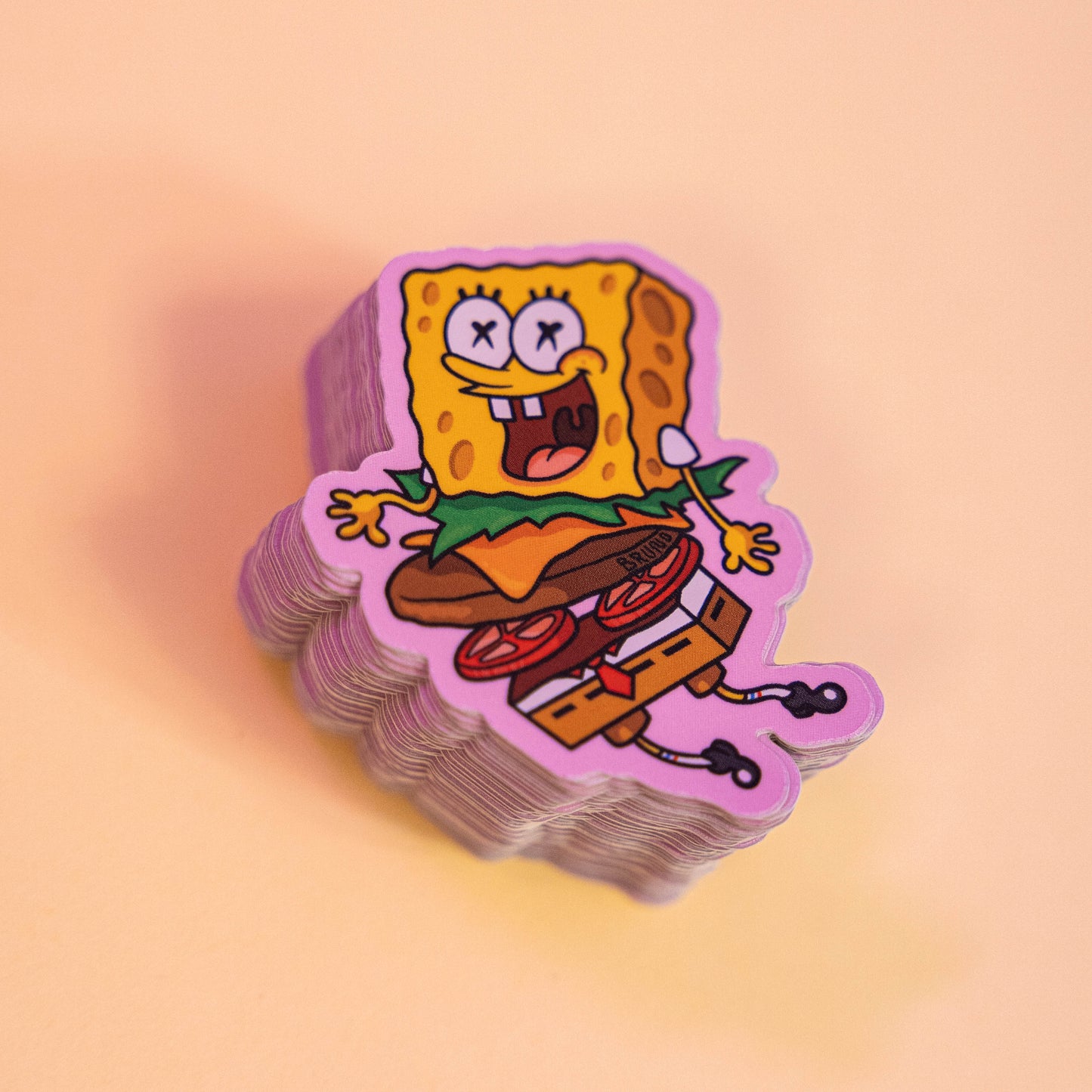 Bob l'Éponge Burger -Illustration digitale imprimée sur stickers Vinyl mat avec effet holographique. Les autocollants sont résistant aux poussières et aux éclaboussures. Veillez bien à les coller sur une surface lisse, propre et sèche pour un bon maintient. Par exemple sur un casque, un vélo, un frigo, une porte, le dos d'un téléphone, etc. Matériaux : Sticker Vinyle mat avec effet holographique.Dimensions : 4,3 x 5,8 cm Vendu à l'unité-Brunograffer