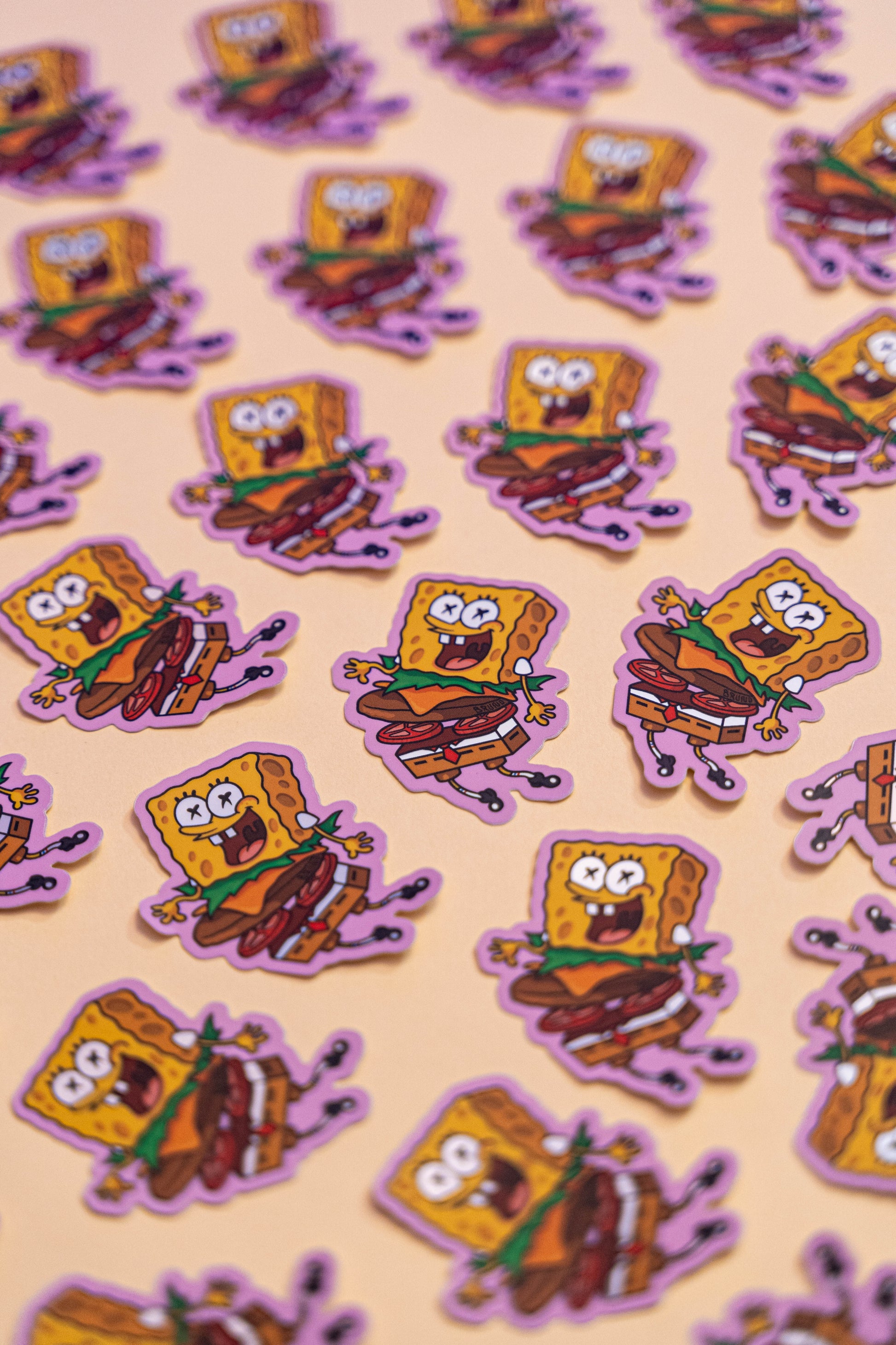 Bob l'Éponge Burger -Illustration digitale imprimée sur stickers Vinyl mat avec effet holographique. Les autocollants sont résistant aux poussières et aux éclaboussures. Veillez bien à les coller sur une surface lisse, propre et sèche pour un bon maintient. Par exemple sur un casque, un vélo, un frigo, une porte, le dos d'un téléphone, etc. Matériaux : Sticker Vinyle mat avec effet holographique.Dimensions : 4,3 x 5,8 cm Vendu à l'unité-Brunograffer