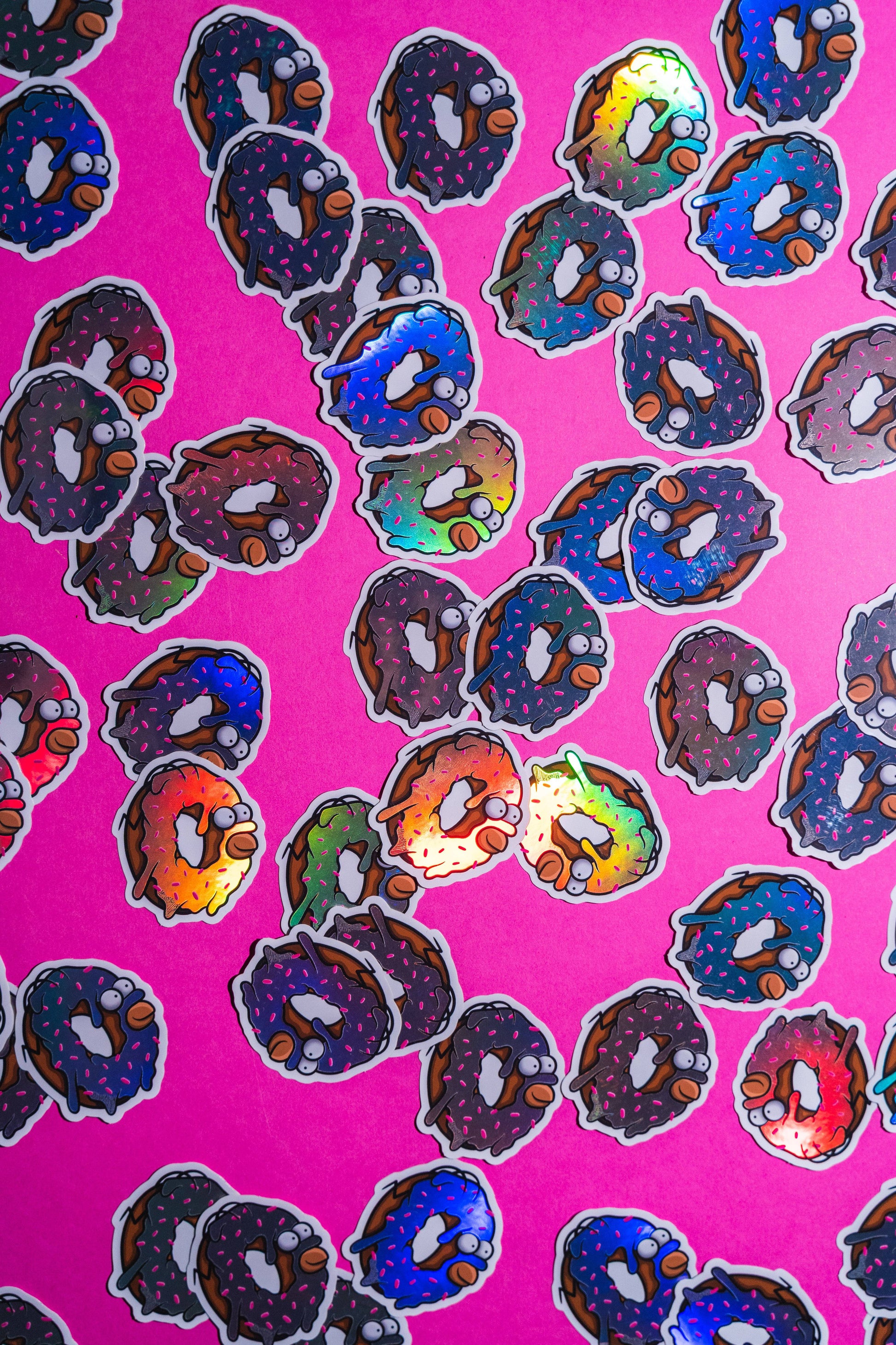 Homer Simpson donut -Illustration digitale imprimée sur stickers Vinyl mat avec effet holographique. Les autocollants sont résistant aux poussières et aux éclaboussures. Veillez bien à les coller sur une surface lisse, propre et sèche pour un bon maintient. Par exemple sur un casque, un vélo, un frigo, une porte, le dos d'un téléphone, etc. Matériaux : Sticker Vinyle mat avec effet holographique.Dimensions : 4,8 x 5,5 cm Vendu à l'unité-Brunograffer