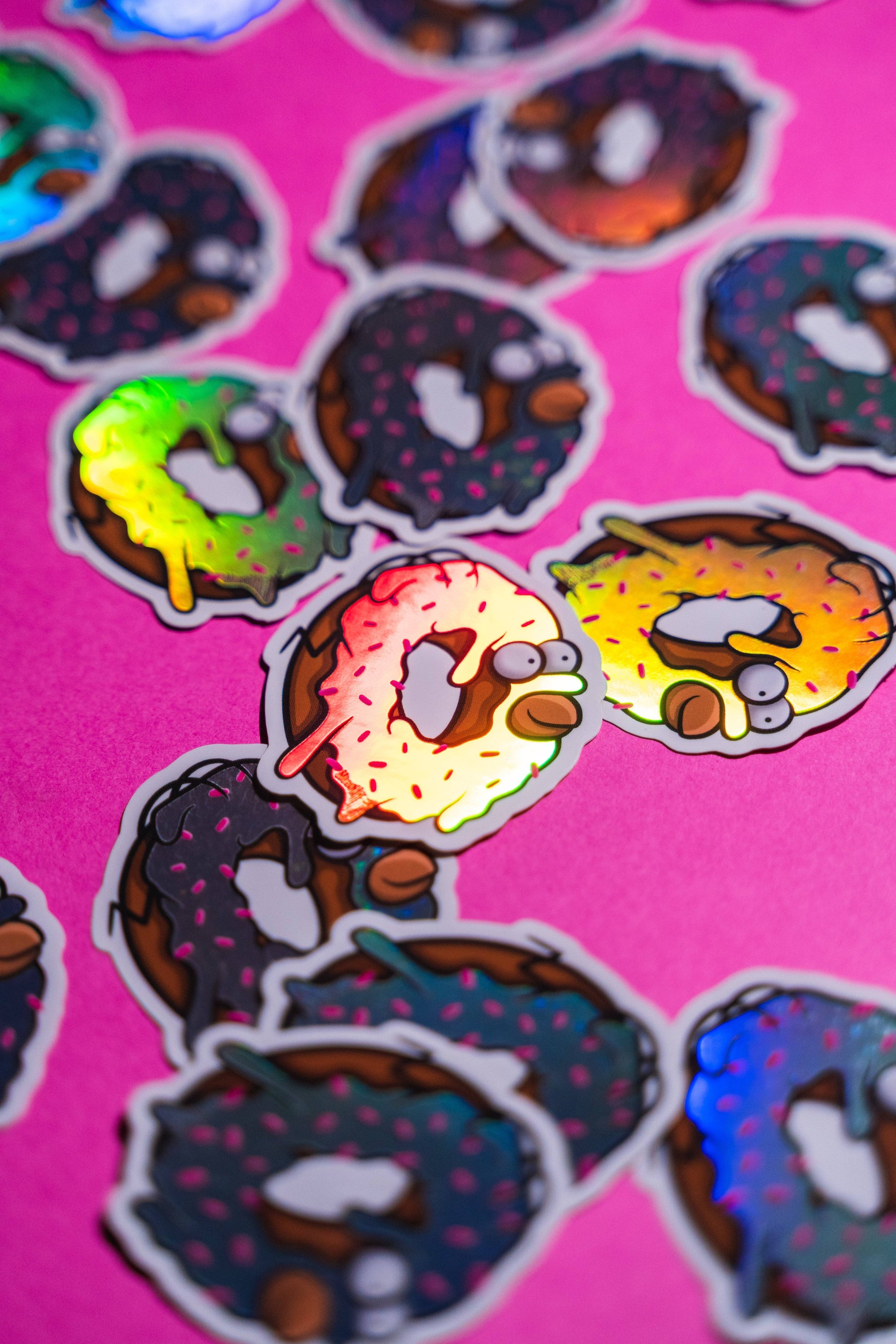 Homer Simpson donut -Illustration digitale imprimée sur stickers Vinyl mat avec effet holographique. Les autocollants sont résistant aux poussières et aux éclaboussures. Veillez bien à les coller sur une surface lisse, propre et sèche pour un bon maintient. Par exemple sur un casque, un vélo, un frigo, une porte, le dos d'un téléphone, etc. Matériaux : Sticker Vinyle mat avec effet holographique.Dimensions : 4,8 x 5,5 cm Vendu à l'unité-Brunograffer
